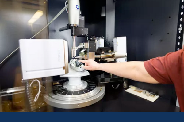 Faculty member points to X-Ray Crystallography instrumentation