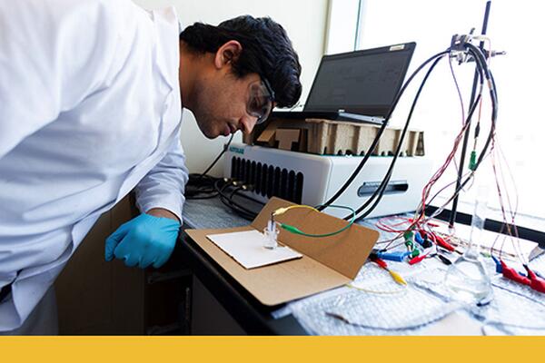 Student wearing safety goggles performs a chemistry experiment