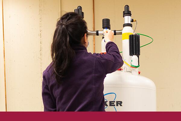 Student adjusts lab equipment used for chemistry experiments