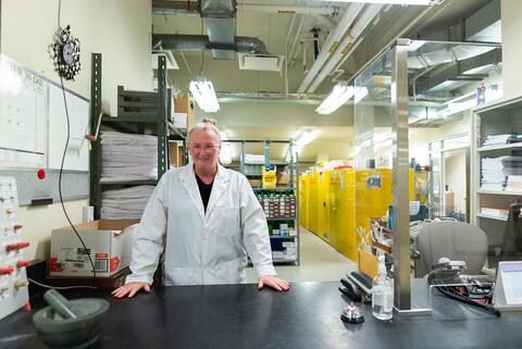 Kim Mackinder, operations assistant, standing behind the front desk of the Science Stores